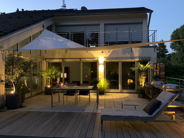 sonnensegel am abend auf einer beleuchtetetn terrasse