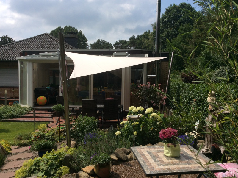 Dreieck, klein, weiß im Garten weißes, dreieckiges Sonnensegel an drei Pfosten im Garten über Sitzgruppe