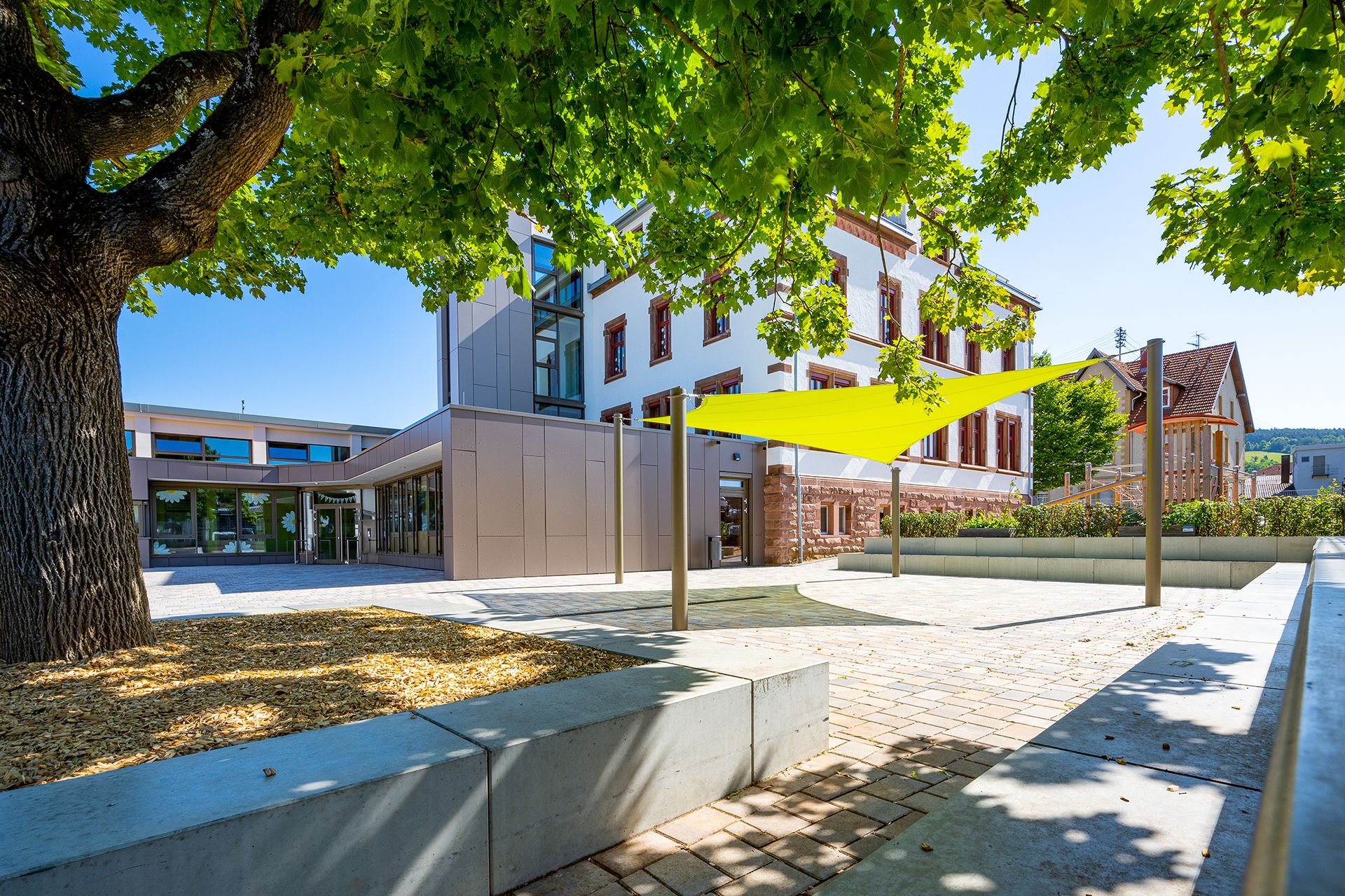 grünes_klassenzimmer gelbes Sonnensegel auf schulhof